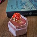 anello dorato con rosa di corallo e foglia argento